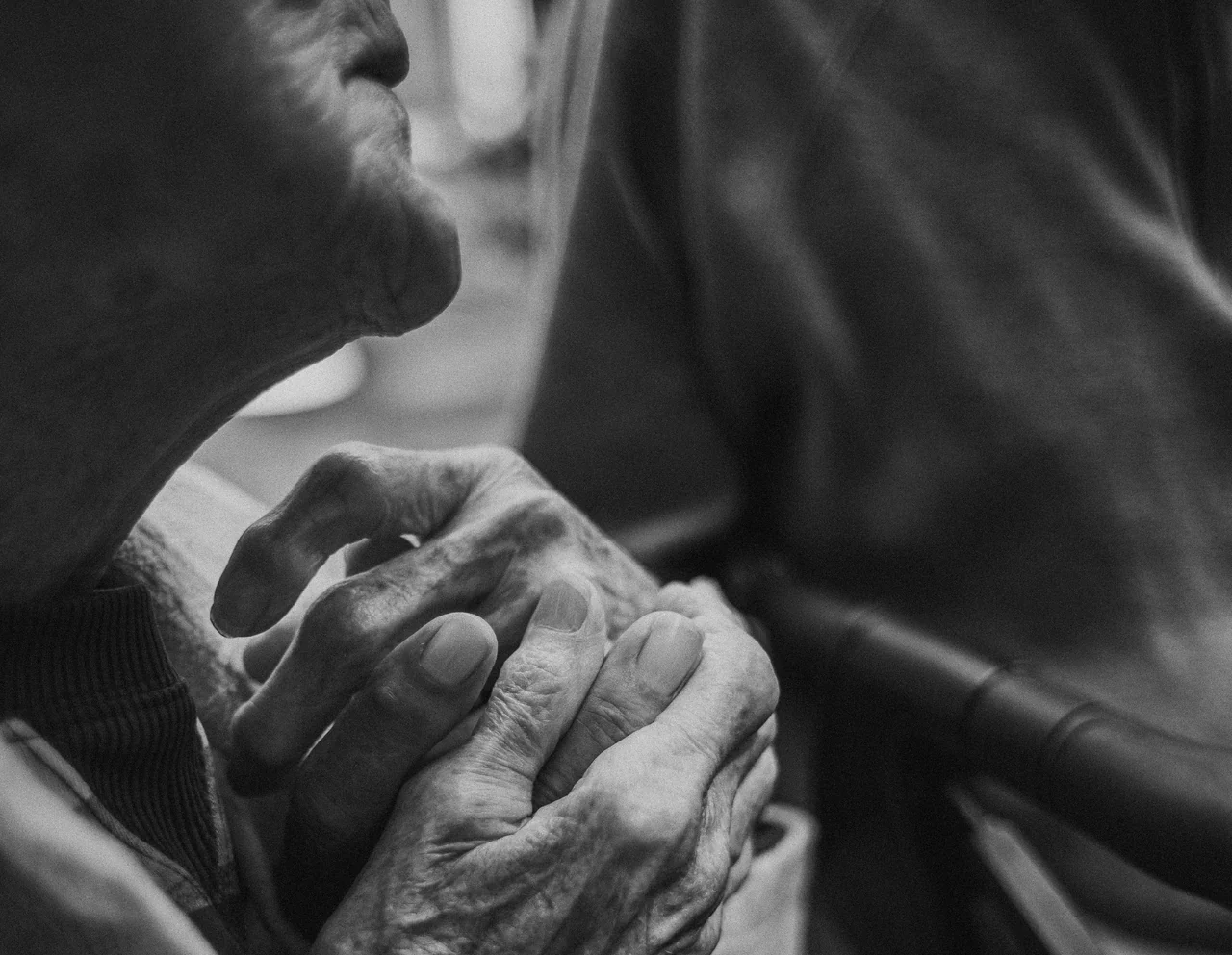 Close-up of clasped hands beside a person’s face