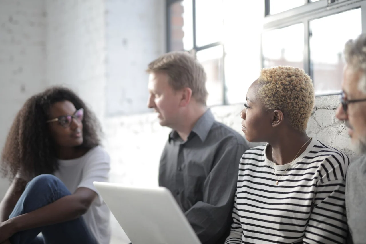 People exchanging ideas while working together by a window